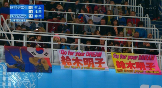 浅田真央の写真の横断幕の顔の部分に、南朝鮮国旗（大清国属旗）を被せて覆い隠す南朝鮮人