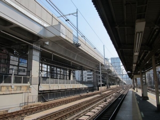 神田駅東京方の高架橋。防音壁の設置が終わり、架線柱が立ち始めている。